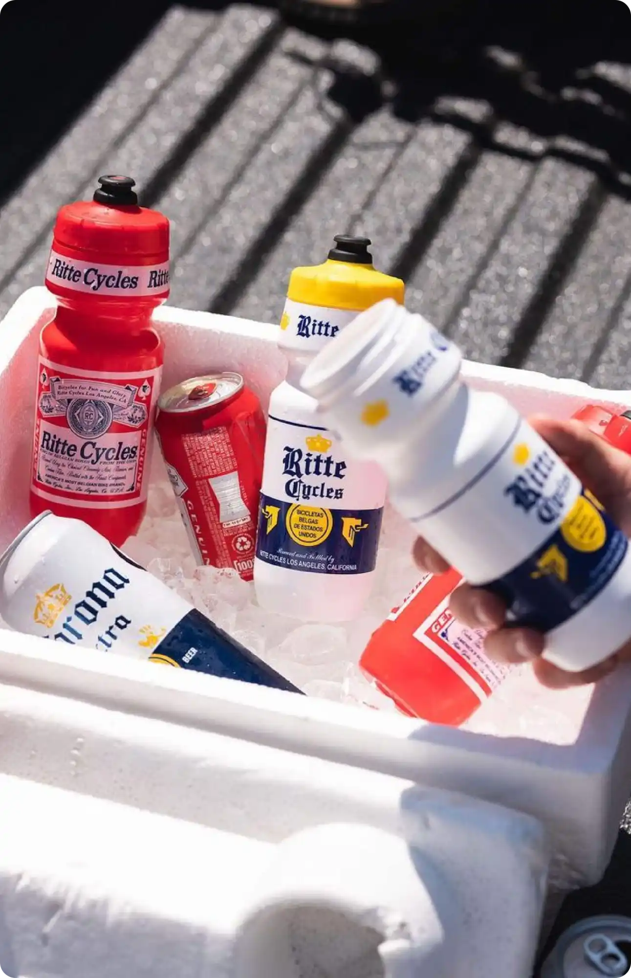 Beverage bottles and cans in a cooler filled with ice.