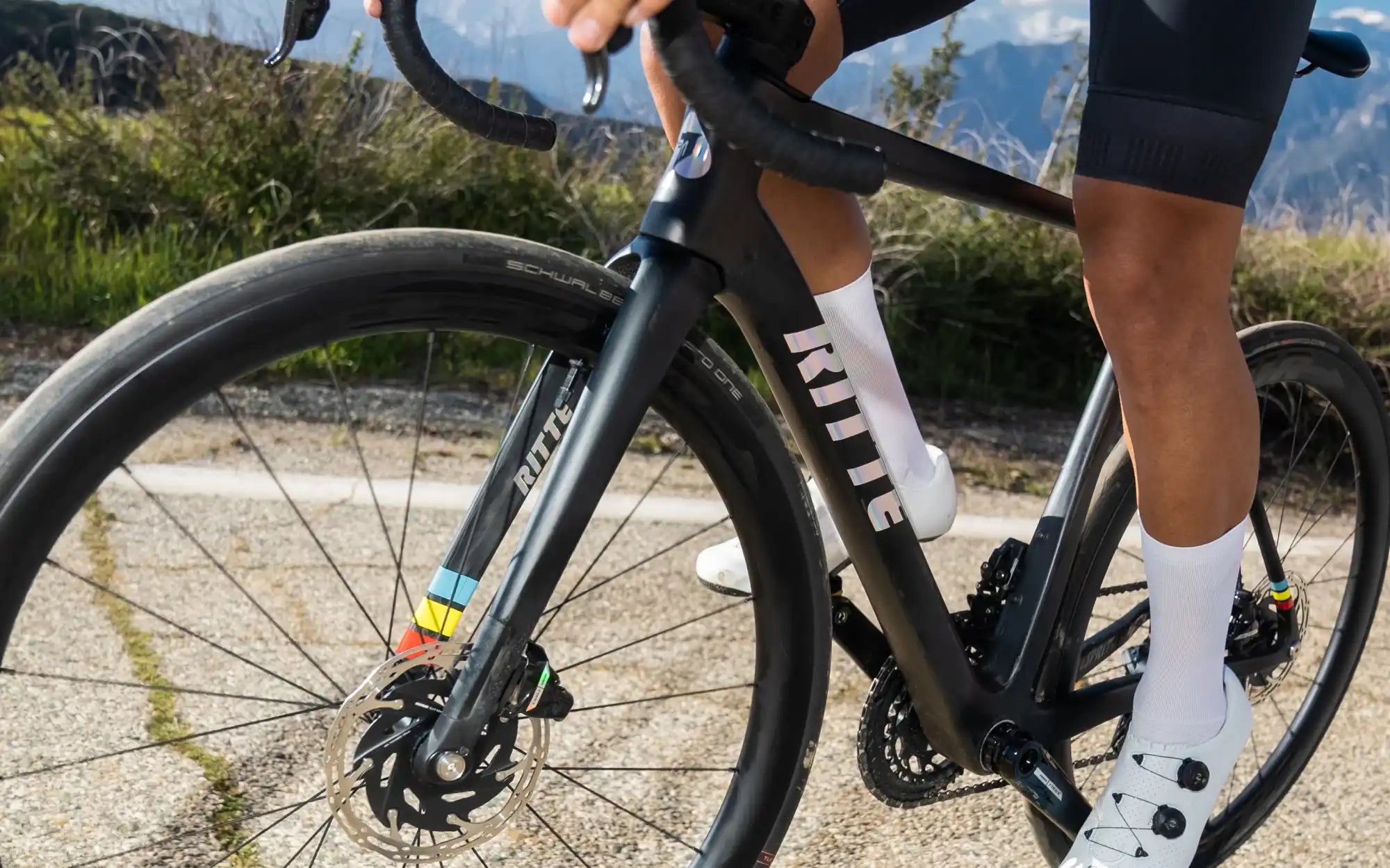 Black road bike with disc brakes and white cycling socks.