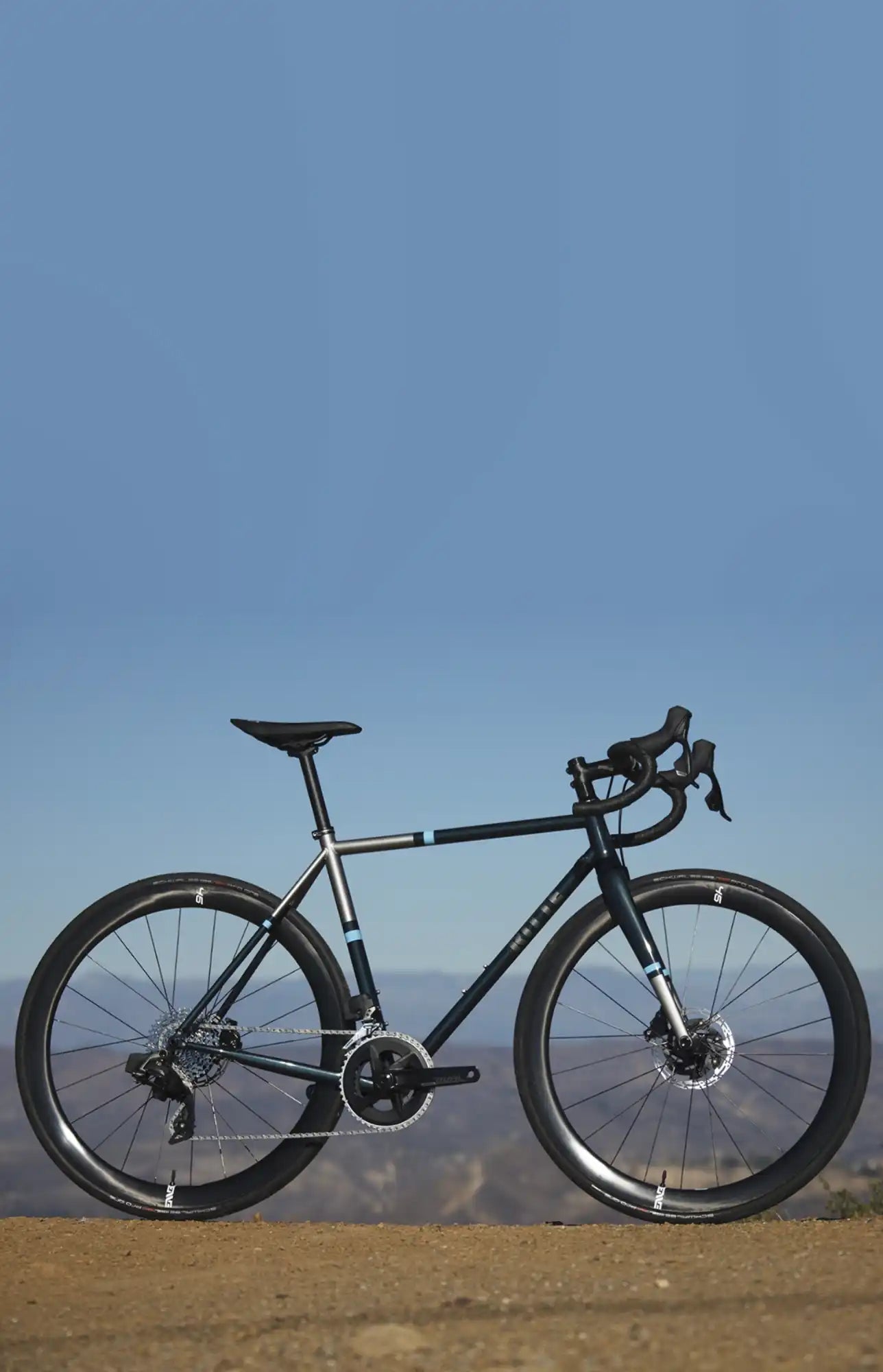 Black road bike with drop handlebars and disc brakes.
