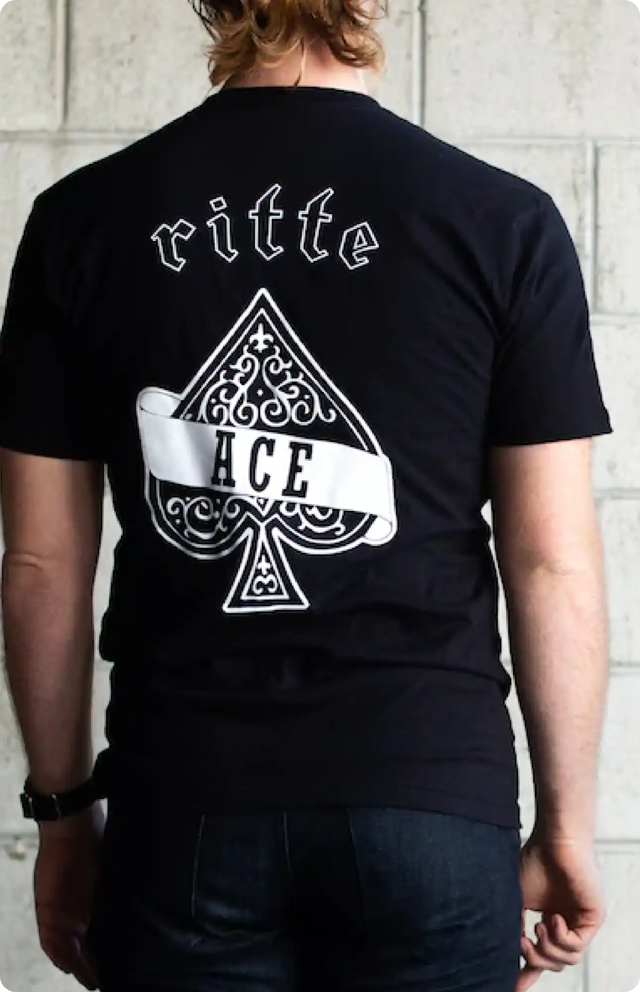 Black t-shirt with a decorative ace of spades design and text on the back.