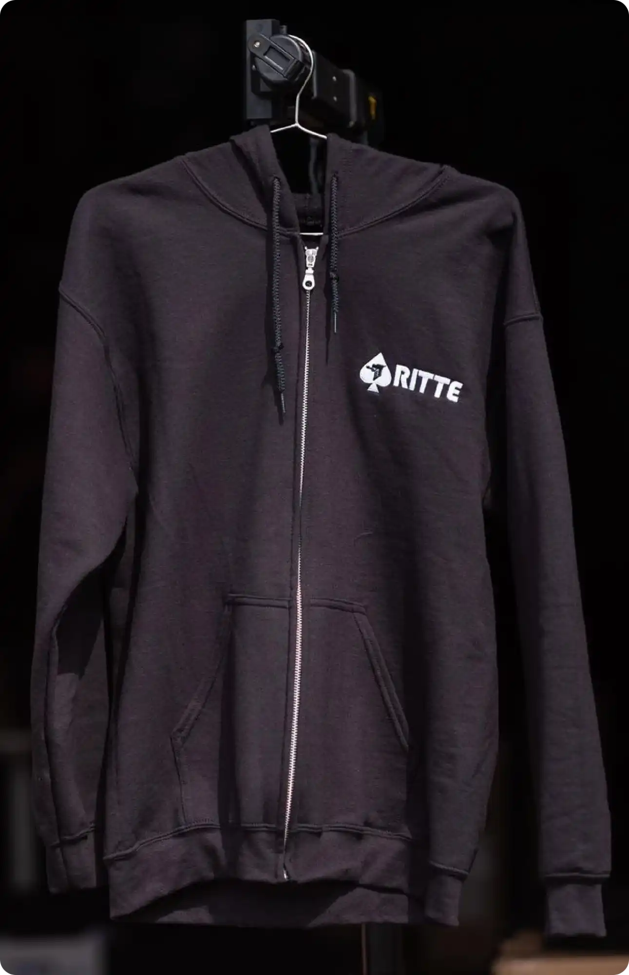 Black zip-up hoodie with a white RITTE logo on the chest.