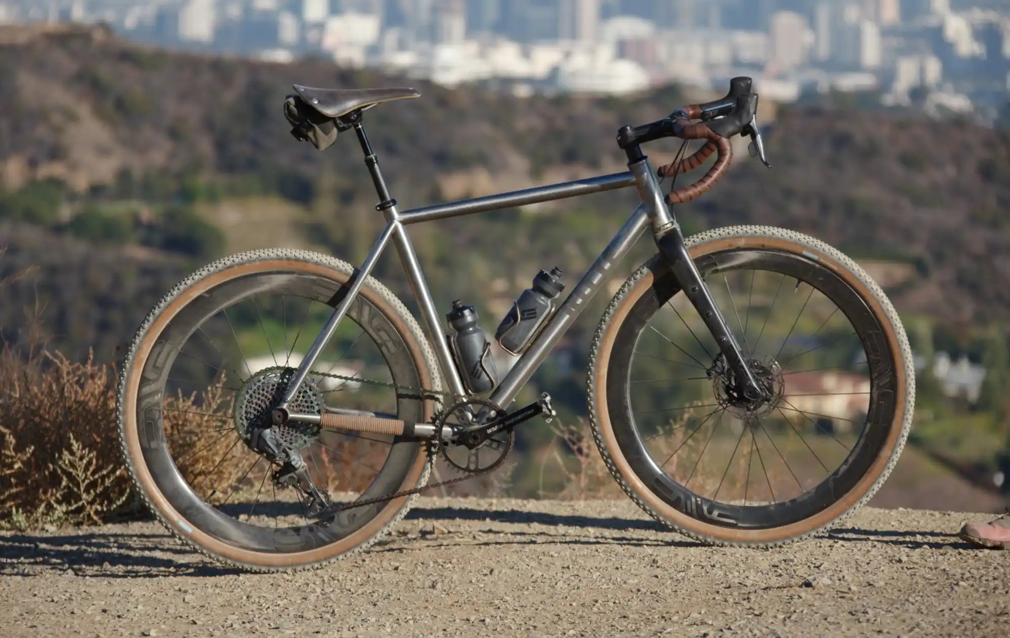 Gray gravel bicycle with wide tires and drop handlebars.