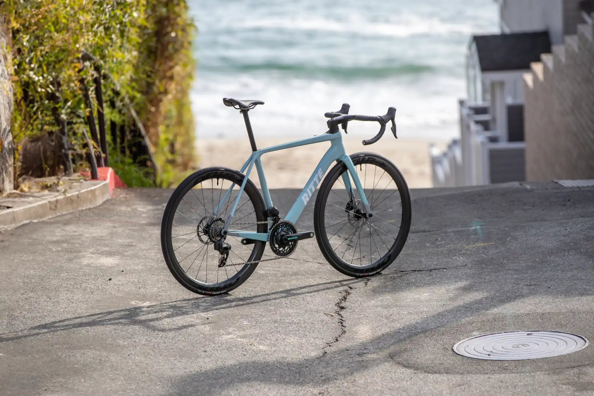 Light blue road bike with disc brakes and drop handlebars.