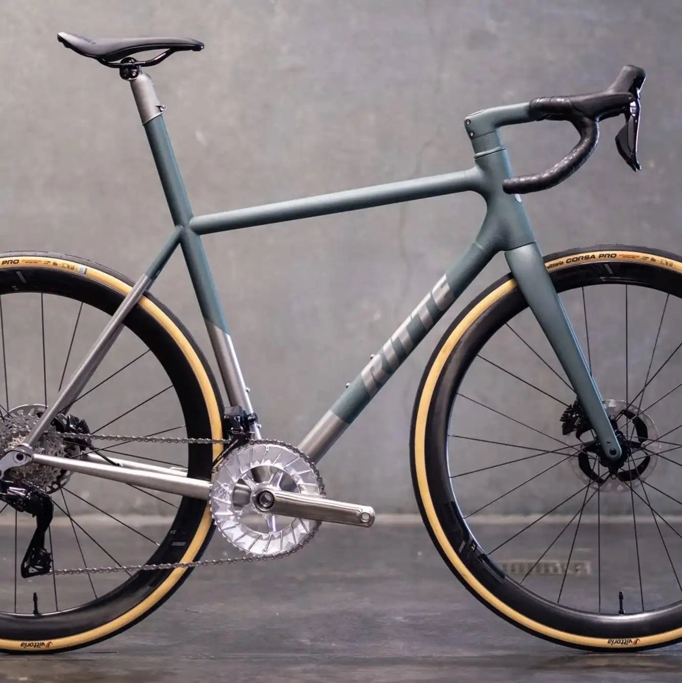 Matte gray road bike with tan sidewall tires and disc brakes.