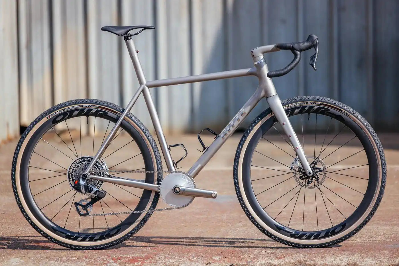 Modern gravel bike with disc brakes and wide tires in a matte gray finish.