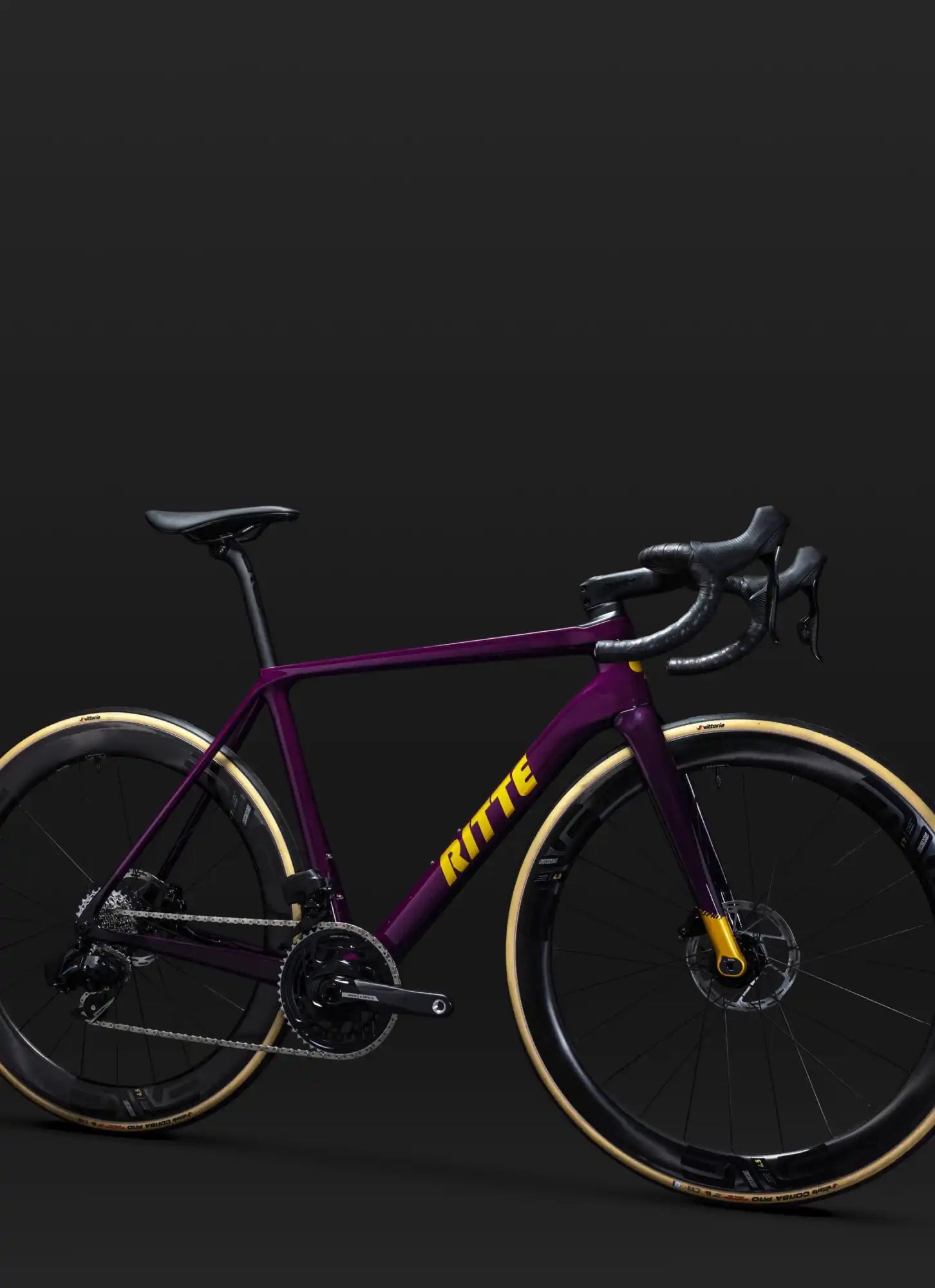 Purple and yellow road bike with disc brakes and drop handlebars.