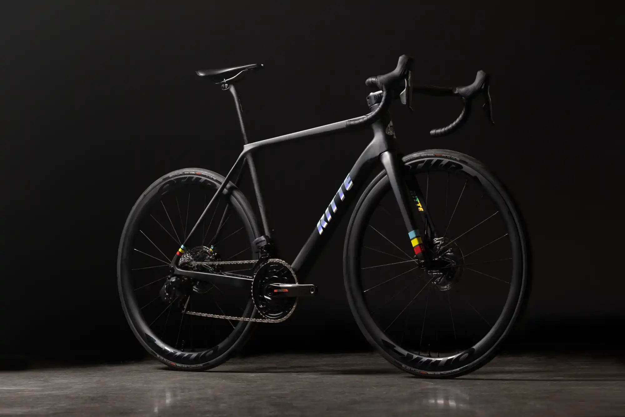 Sleek black road bicycle with white lettering and racing handlebars.