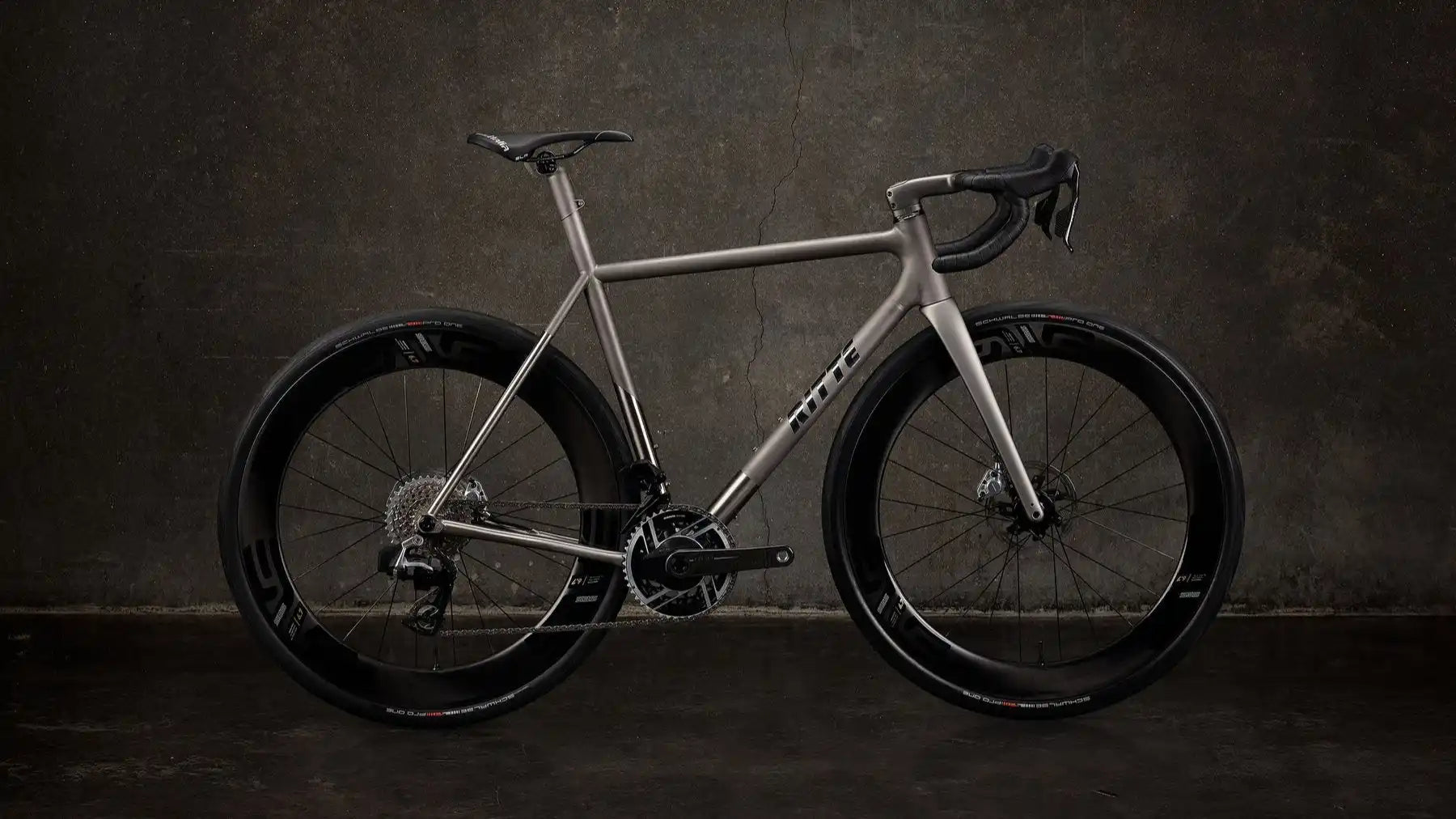 Sleek silver road bike with disc brakes and aerodynamic wheels.