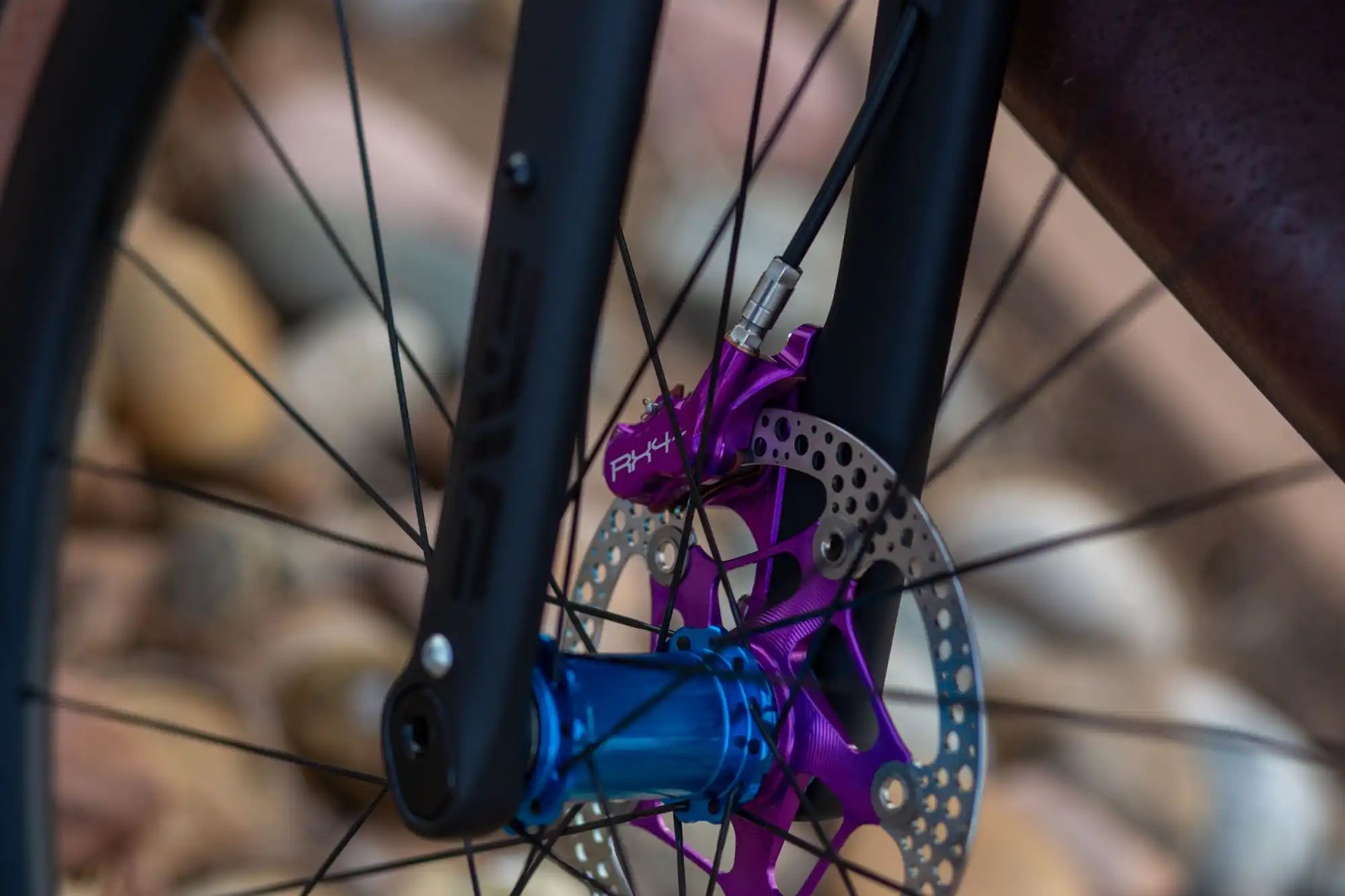 Bicycle wheel hub with purple components and disc brake rotor.