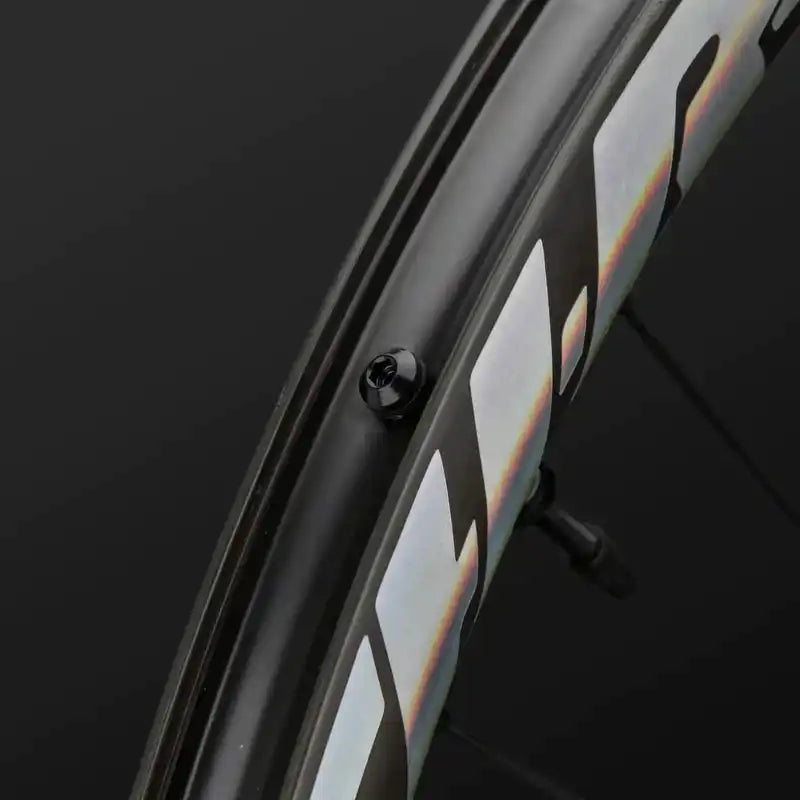 Black bicycle wheel rim with iridescent reflective strips.