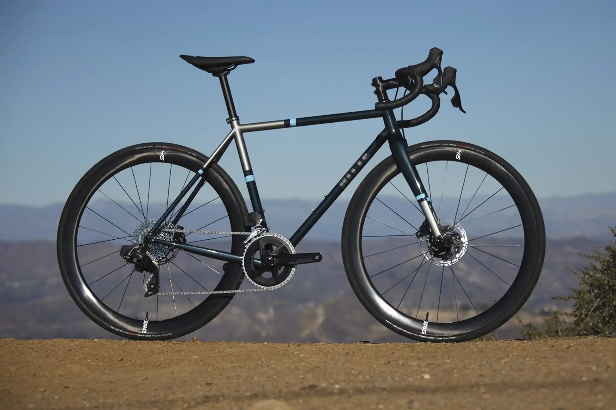 Black road bike with disc brakes and drop handlebars.