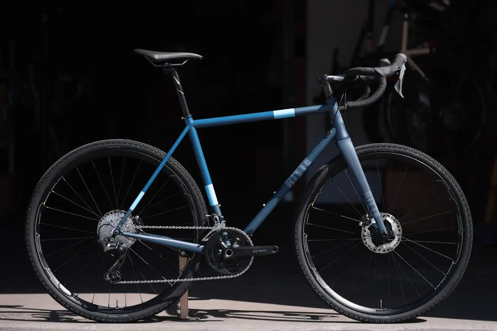 Blue road bike with disc brakes and drop handlebars.