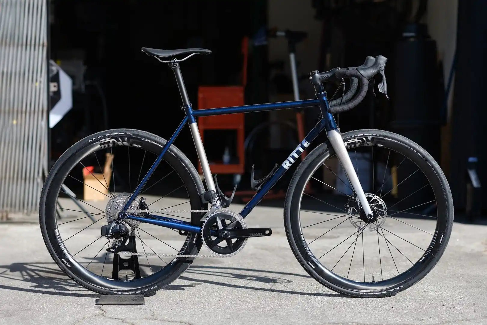 Blue and silver road bike with disc brakes and drop handlebars.