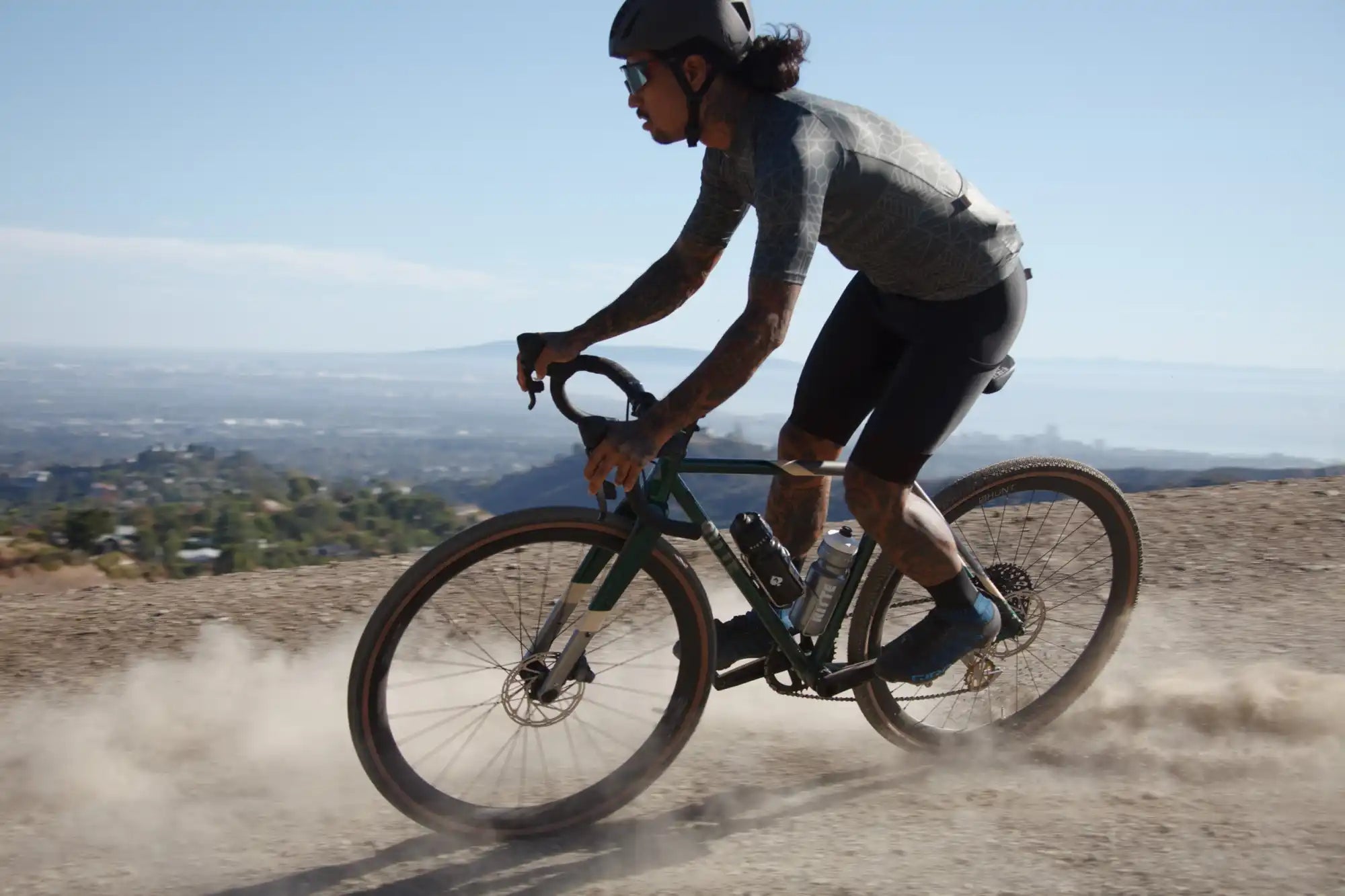 Cyclist riding a gravel bike on a dusty trail.