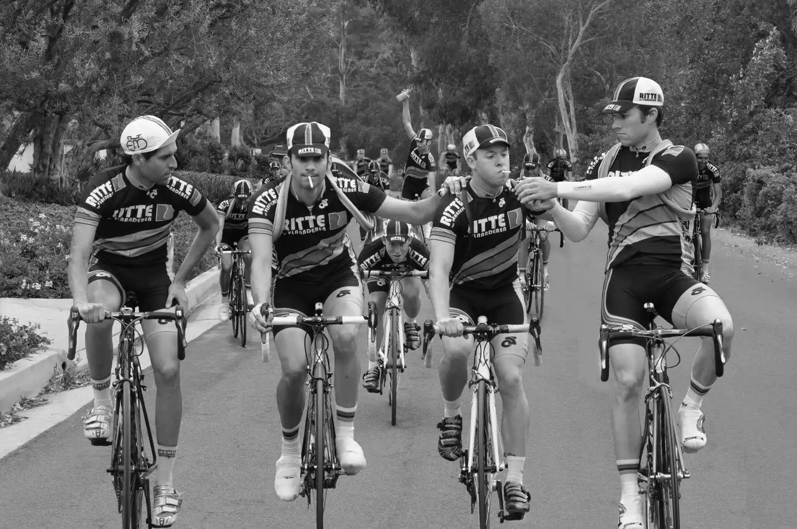 Cyclists riding together in matching team uniforms on road bikes.