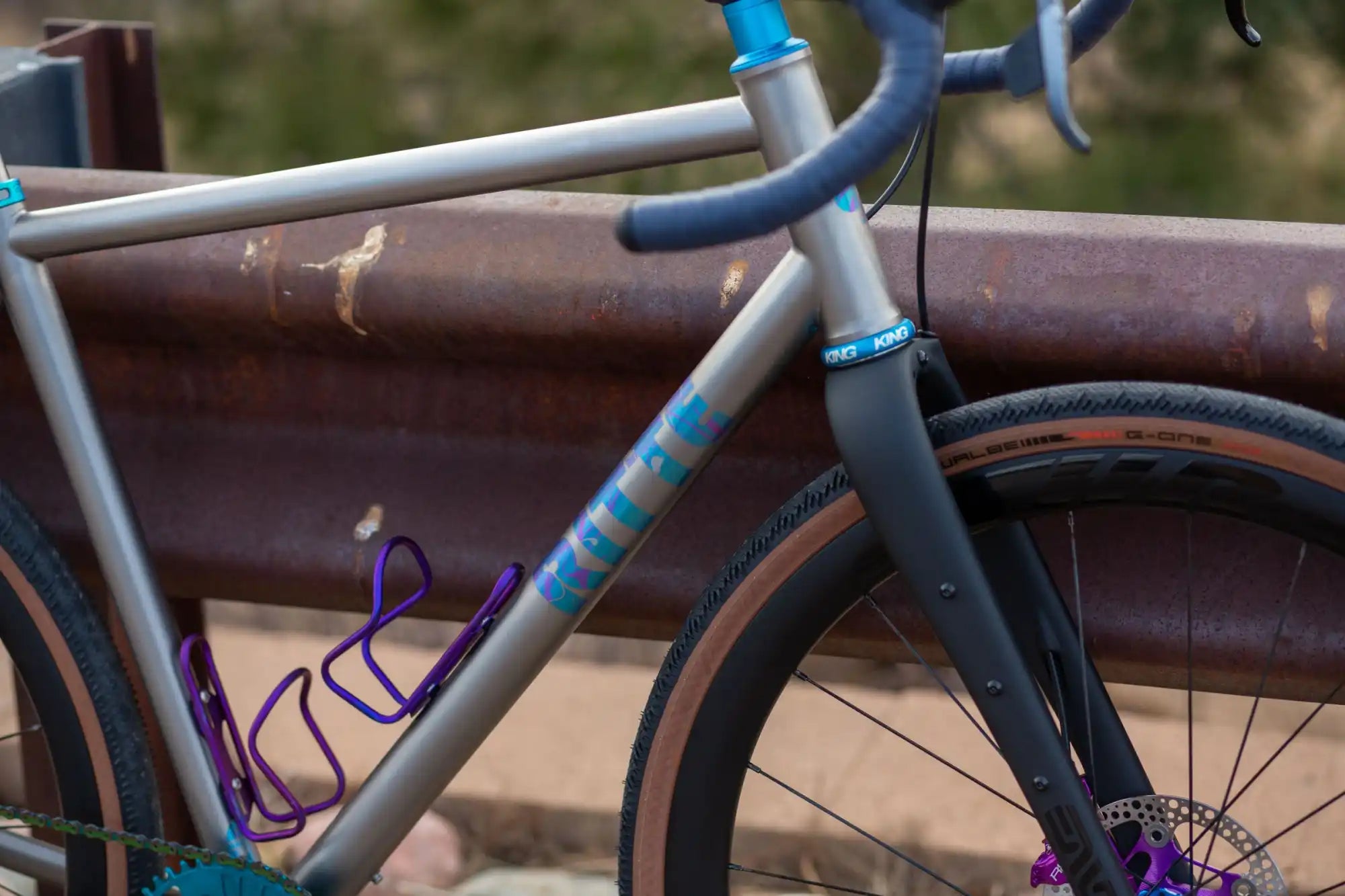 Gray bicycle frame with turquoise accents and purple details.