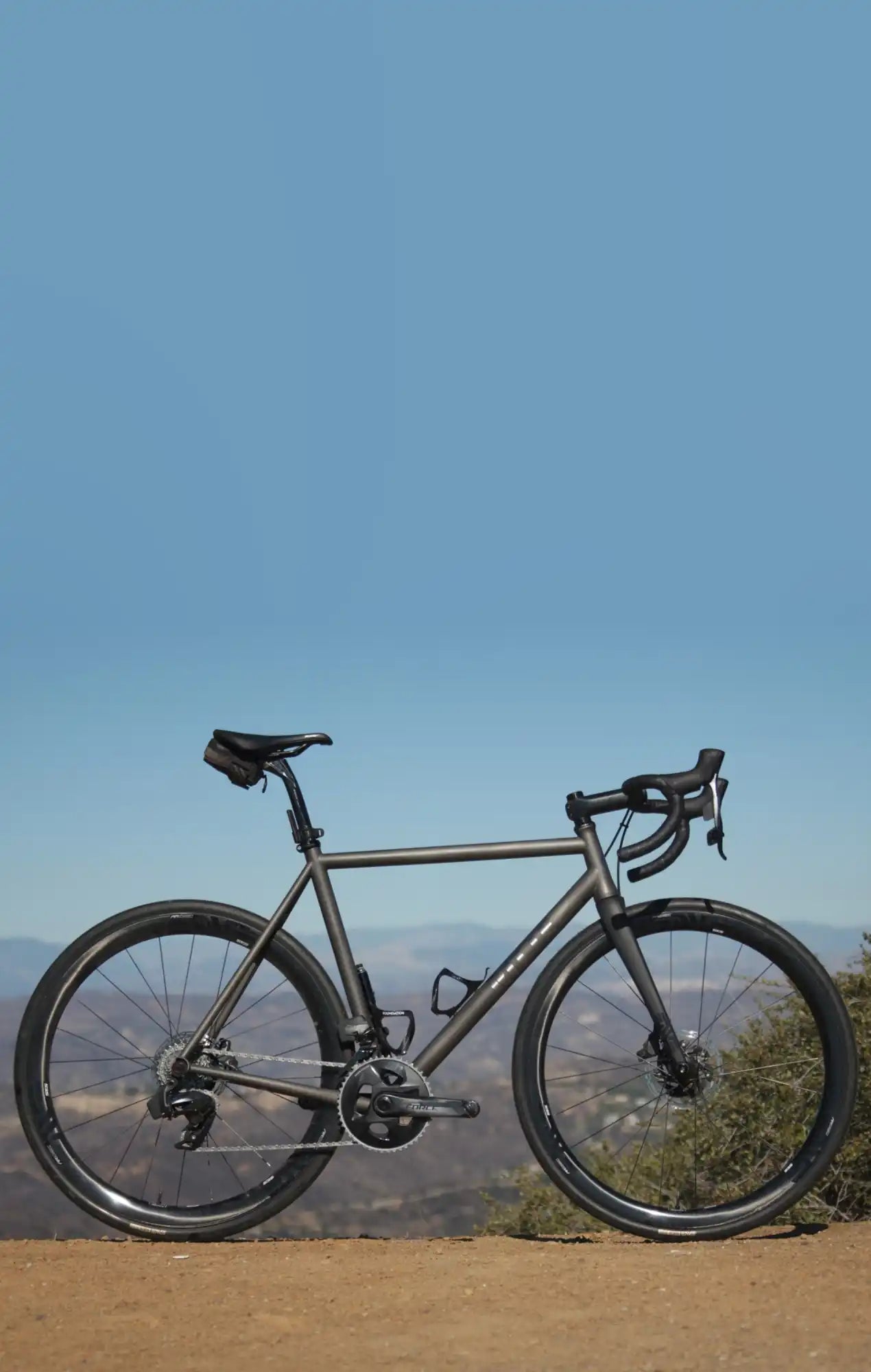 Gray road bike with drop handlebars and disc brakes.