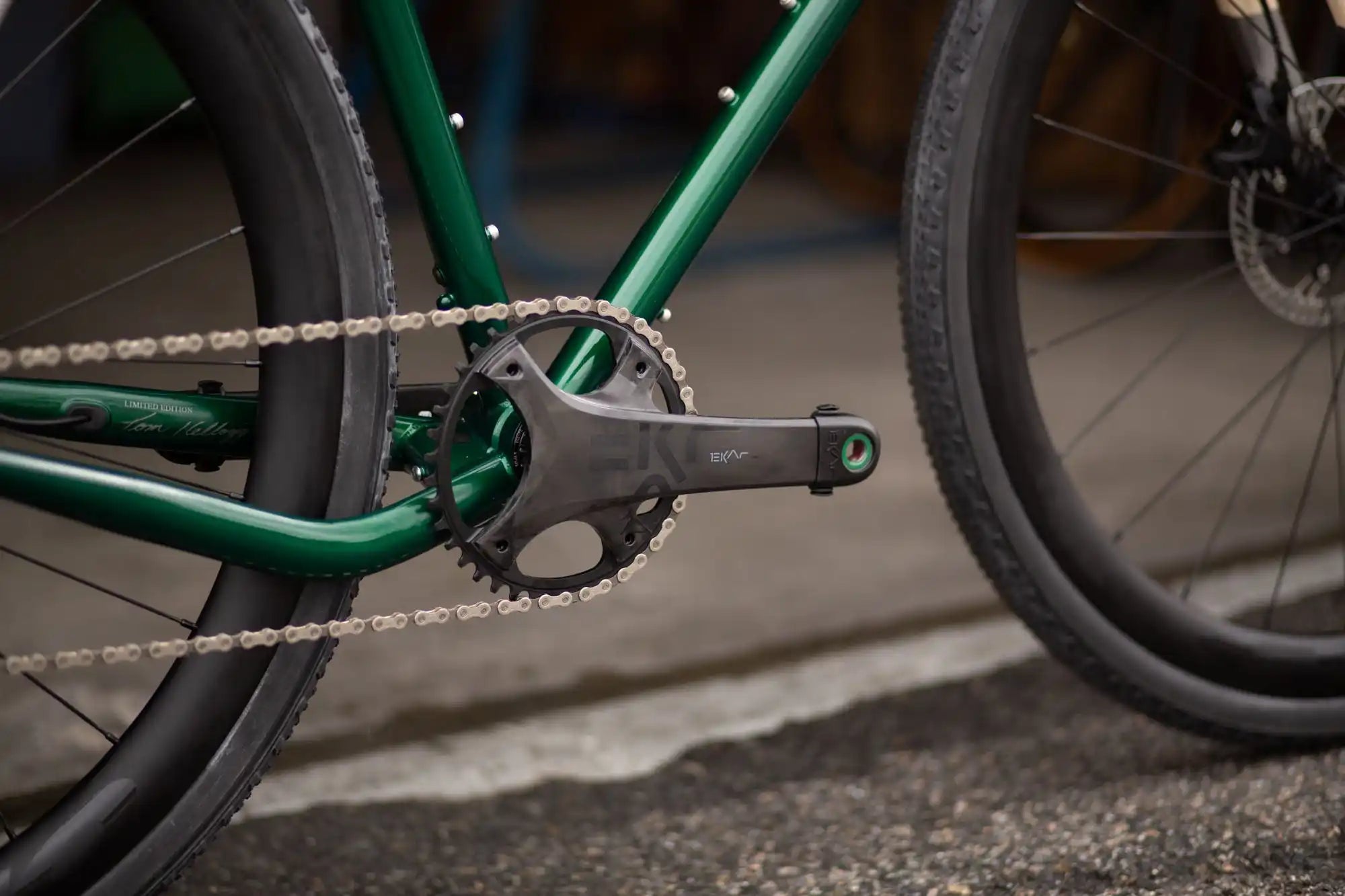 Green bicycle crankset with chain and pedal.