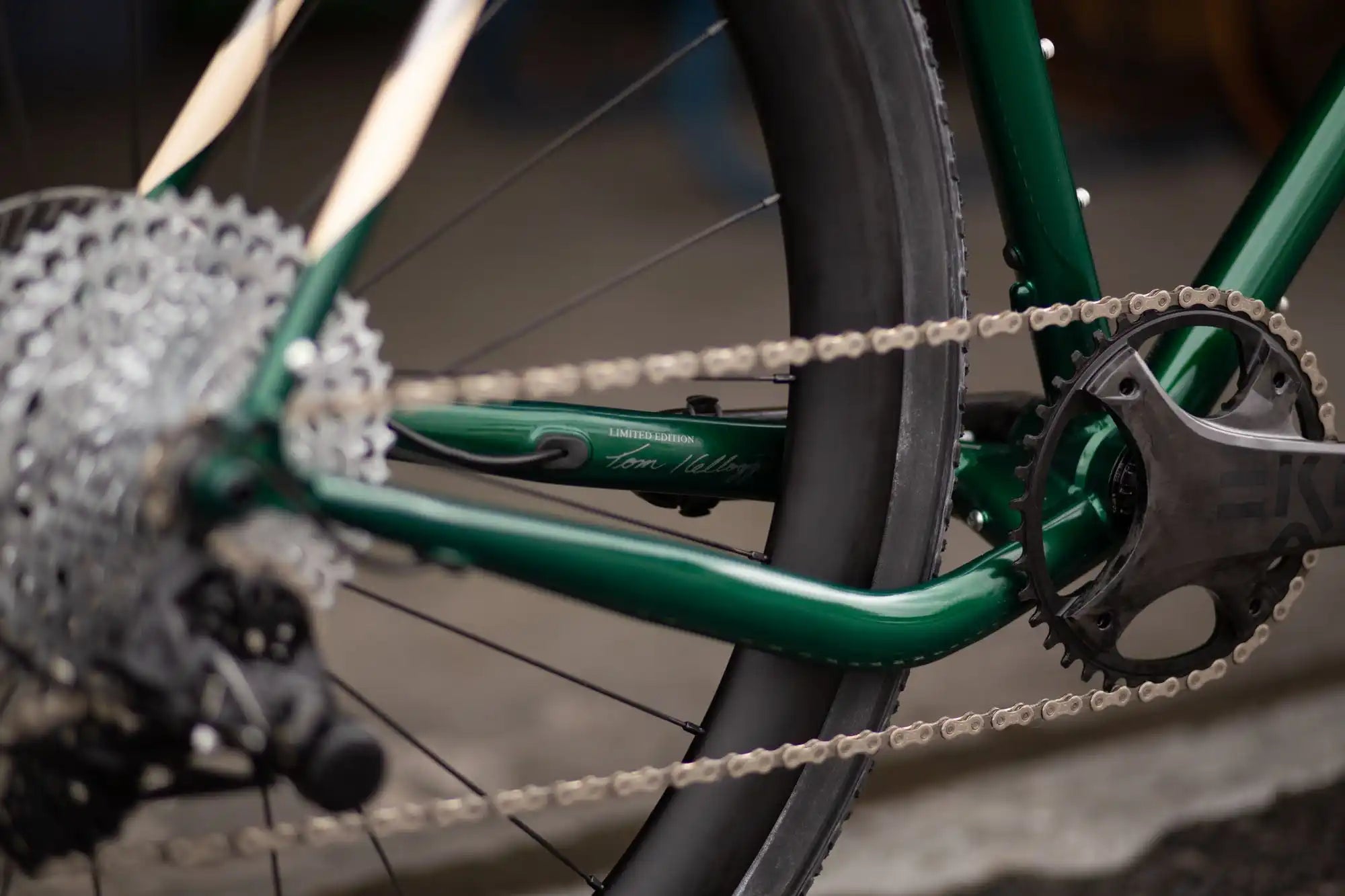 Green bicycle frame with chain and gears in close-up detail.