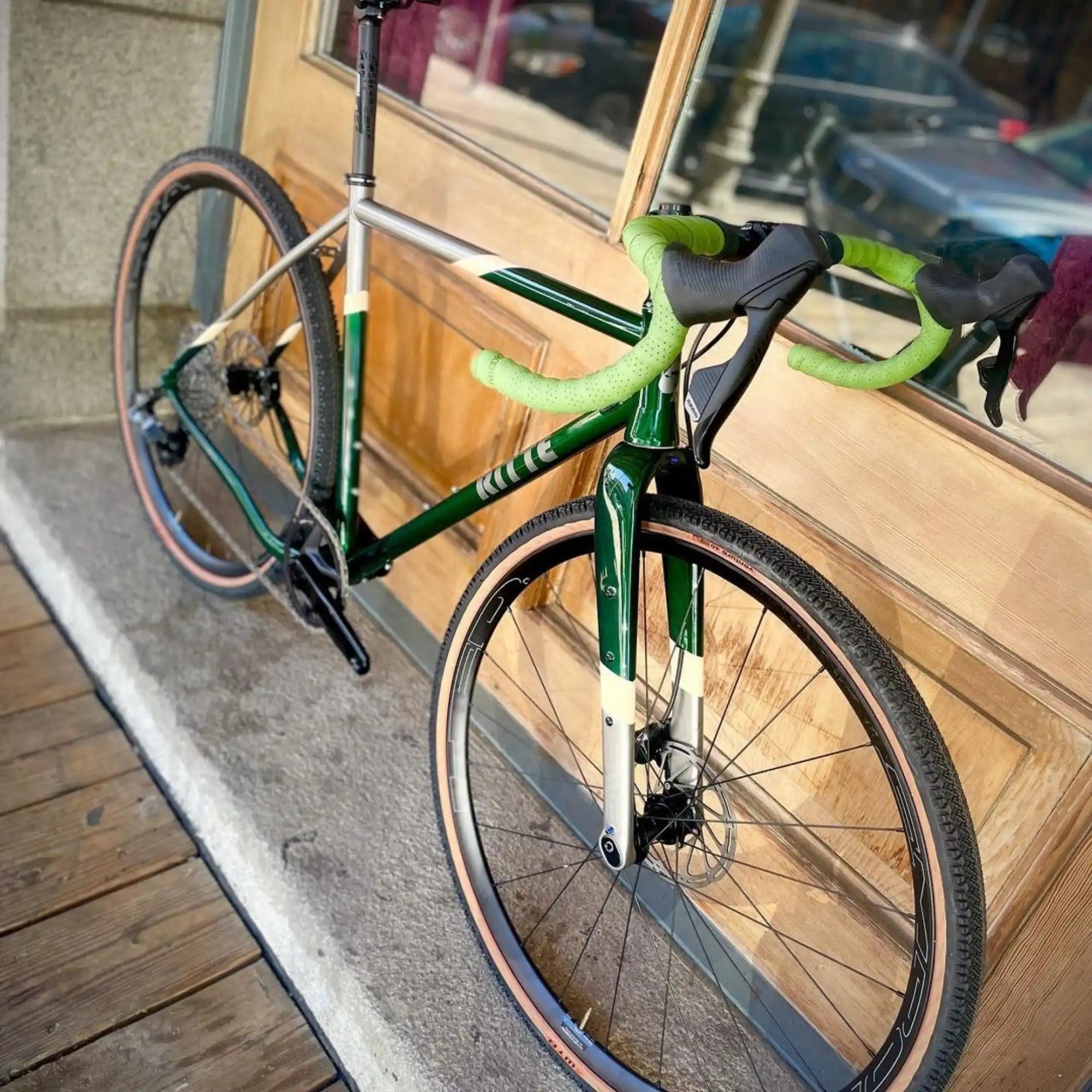 Green road bike with drop handlebars and disc brakes.