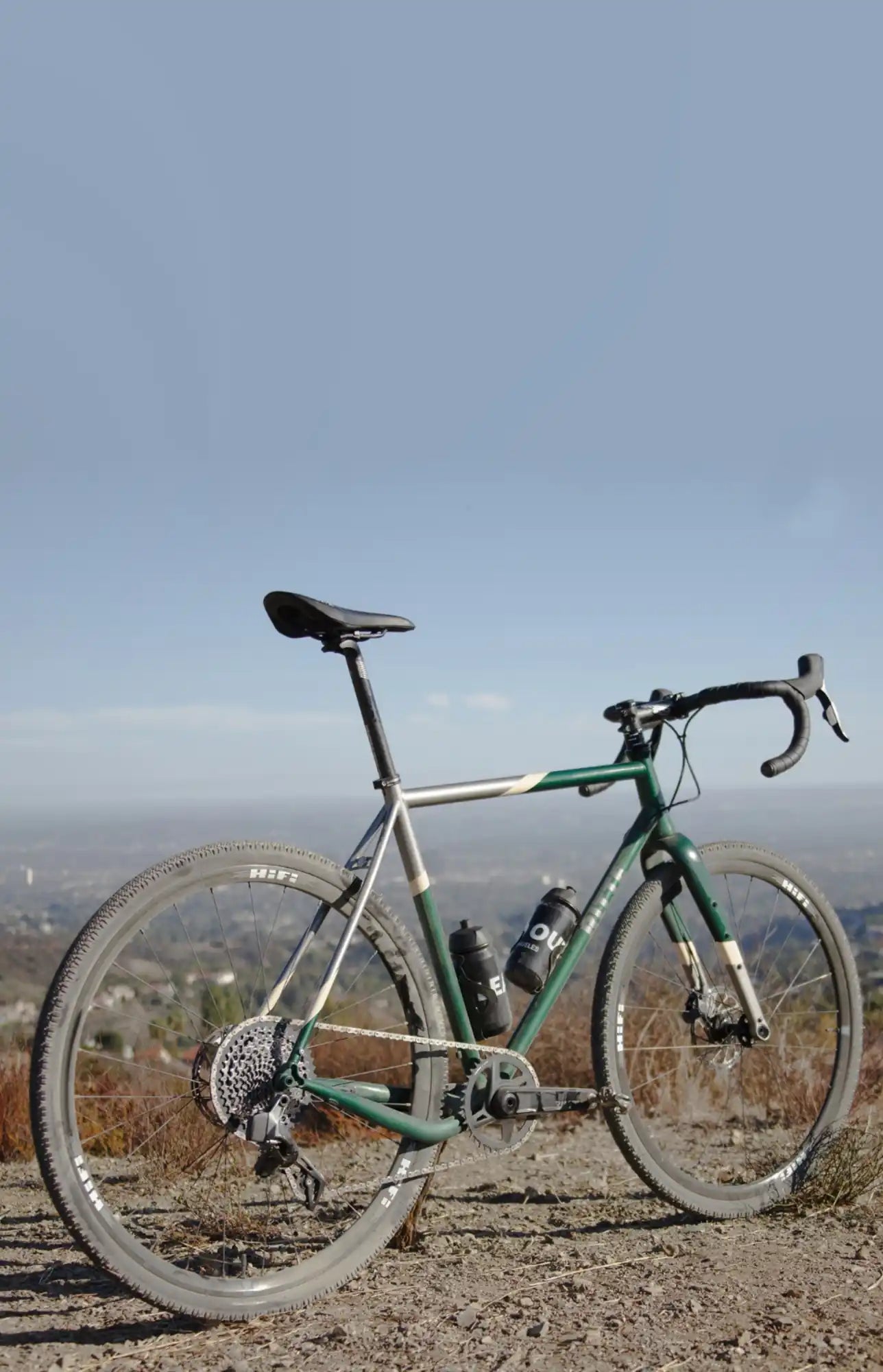 Green and white road bike with drop handlebars and disc brakes.