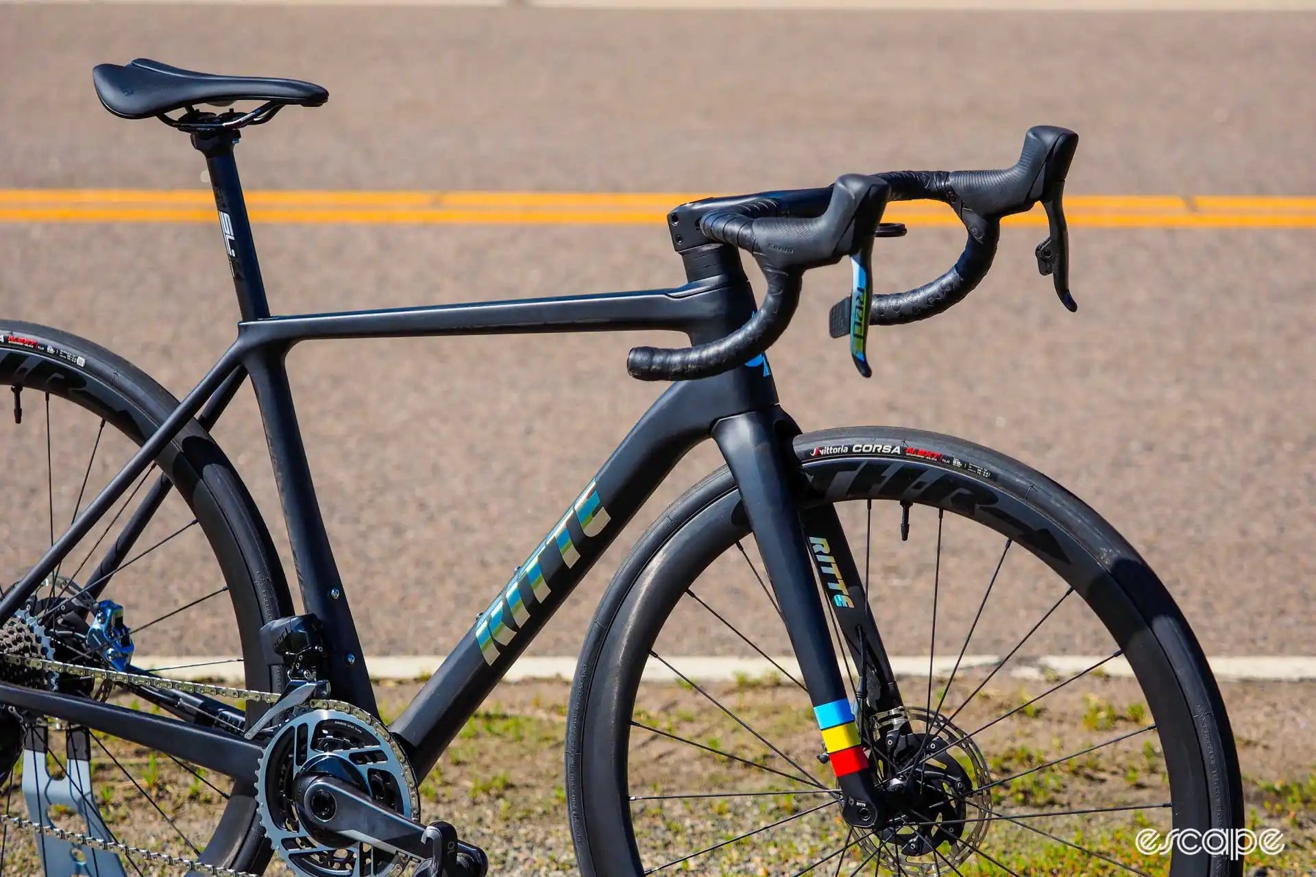 Matte black road bike with subtle teal accents and disc brakes.