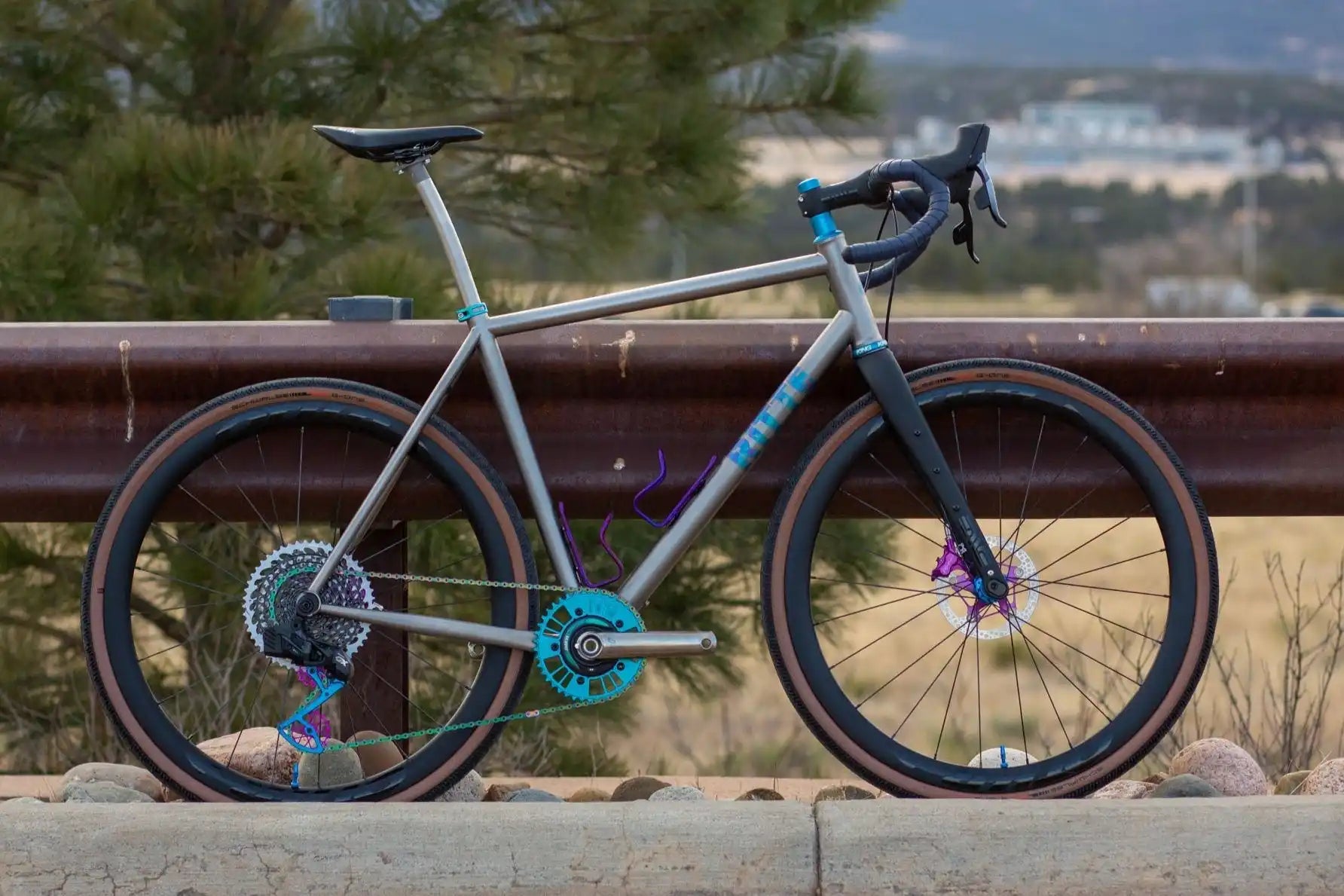 Modern gravel bike with gray frame and turquoise accents.