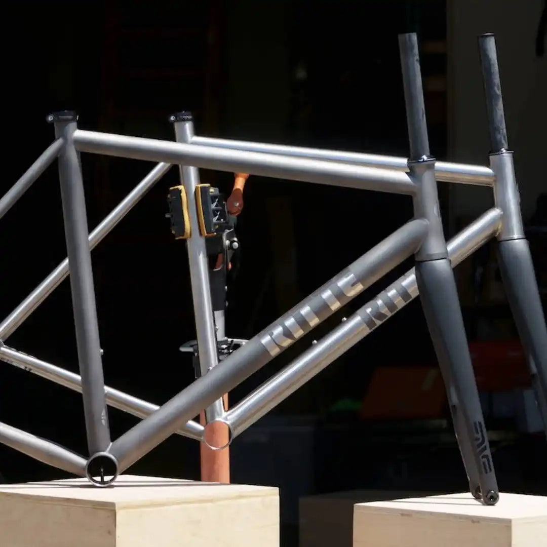 Raw titanium bicycle frame with unpainted metal tubing.