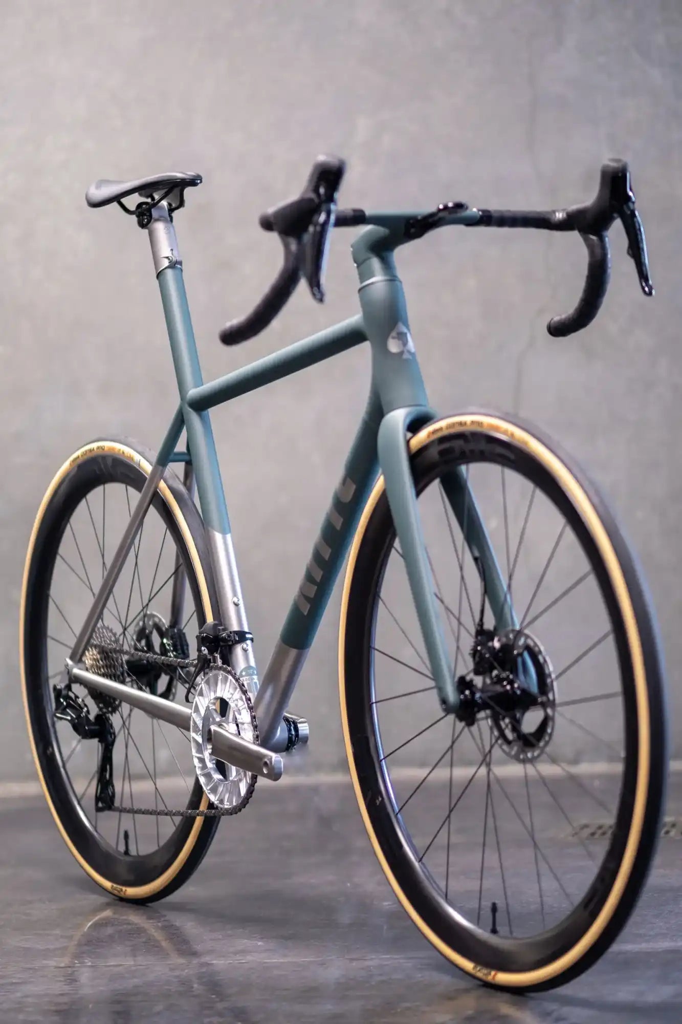 Sleek gray road bike with tan sidewall tires and disc brakes.