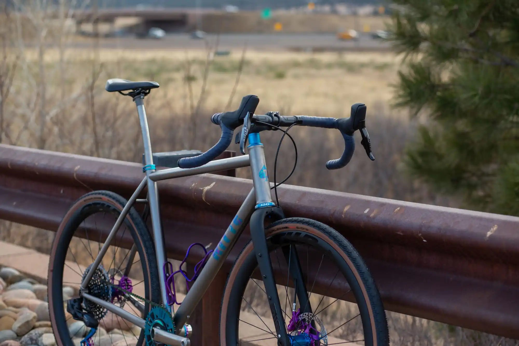 Teal-colored road bike with drop handlebars and purple pedals.