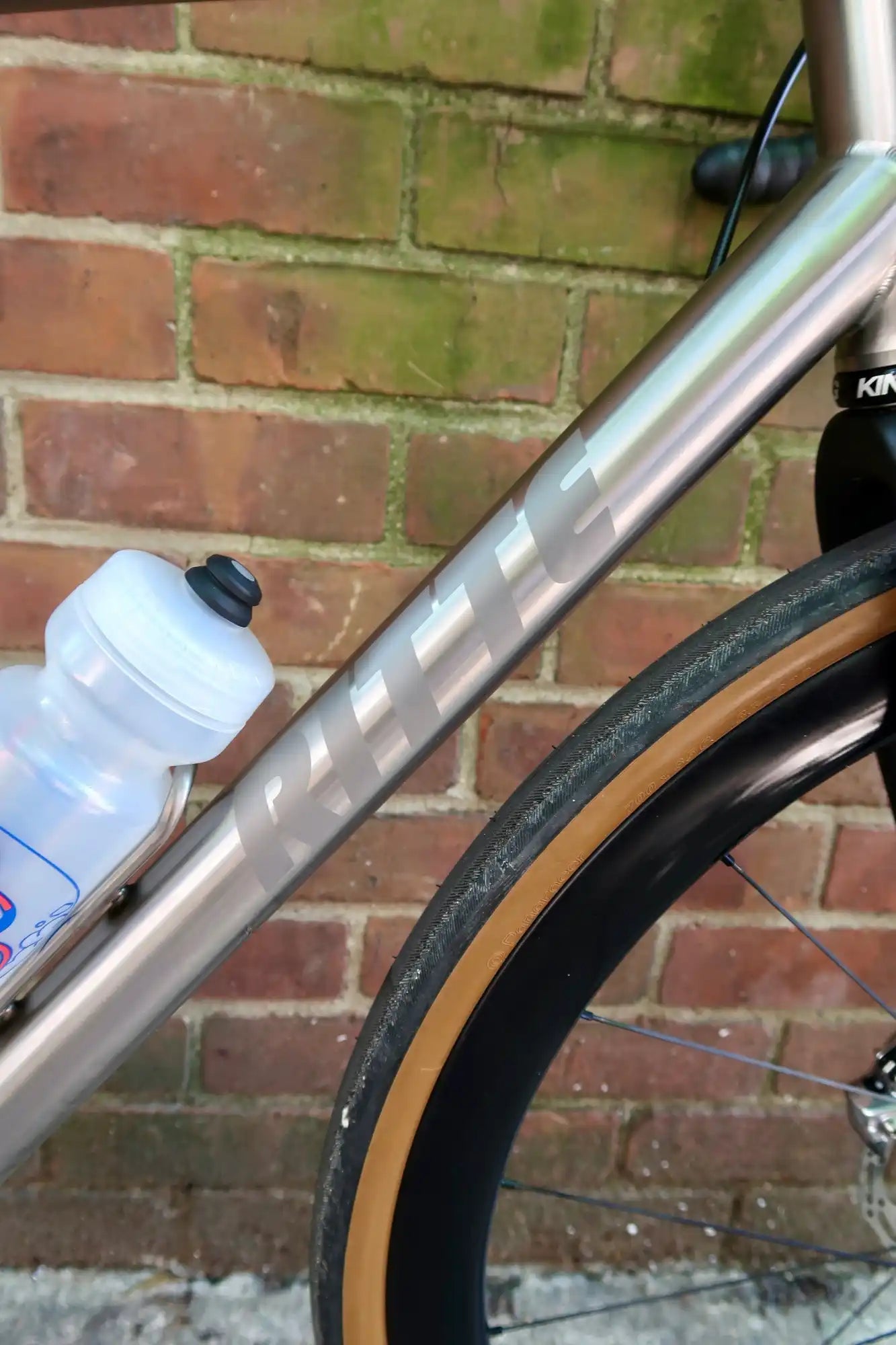 Titanium bicycle frame with water bottle.